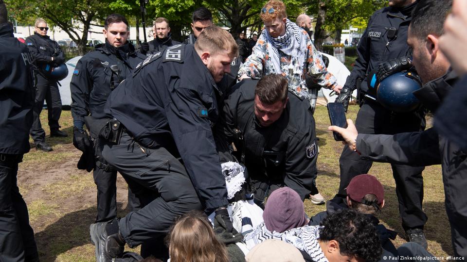 Polizisten beginnen, einen nach dem anderen Demonstranten zu entfernen und halten sie am Boden fest
