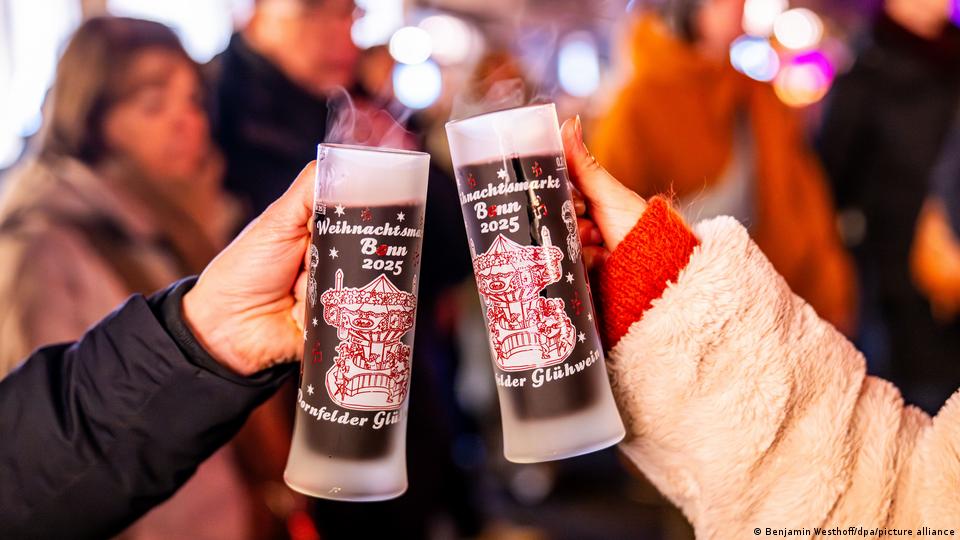 Zwei Frauen stoßen auf dem Bonner Weihnachtsmarkt mit Glühwein an