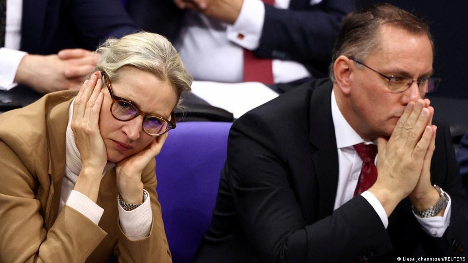  Alice Weidel, den Kopf in den Händen, und Timo Chrupalla, die Hände vor seinem Gesicht gefaltet, sitzen im Parlament