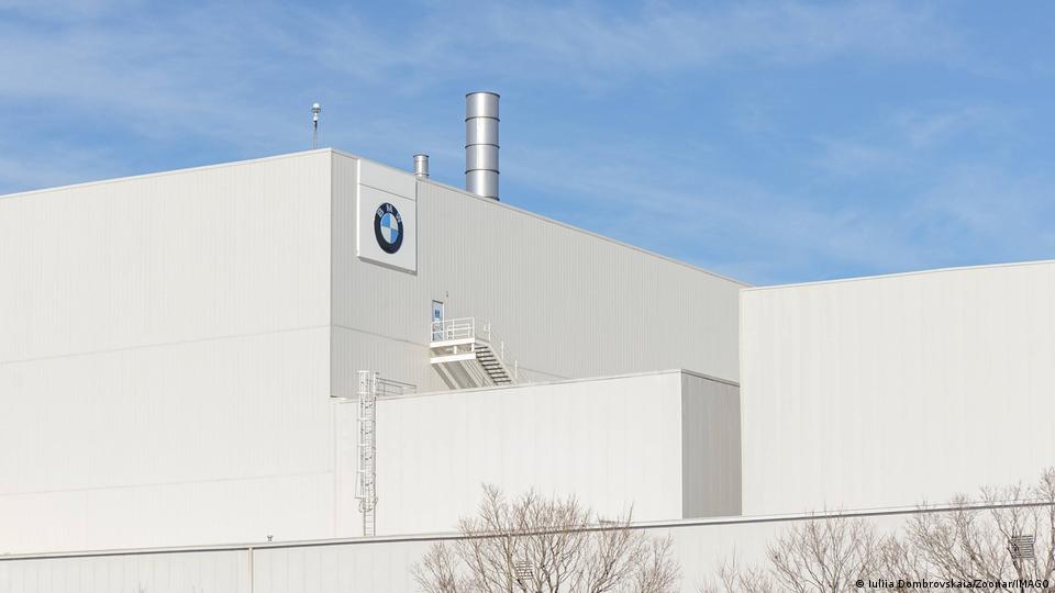 Eine weiße Lagerhalle mit einem BMW-Logo darauf 