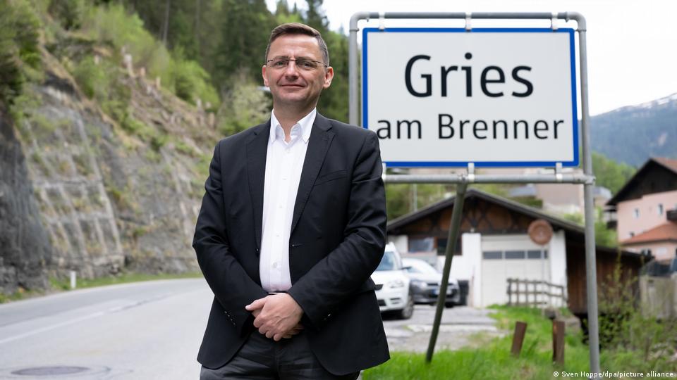 Mann steht vor einem Schild mit der Aufschrift „Gries am Brenner“