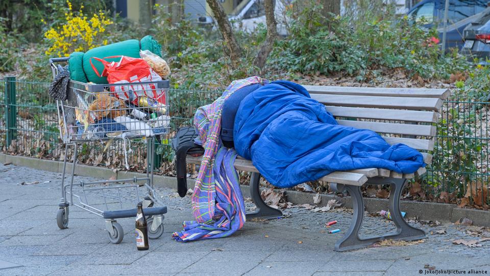Ein Obdachloser auf einer Parkbank in Berlin