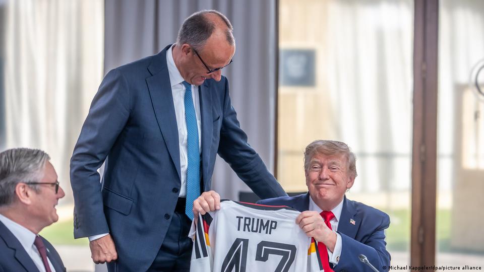 Bundeskanzler Friedrich Merz überreicht US-Präsident Donald Trump beim G7-Gipfel im französischen Evian ein Trikot der deutschen Nationalmannschaft mit Trumps Namen und der Nummer 47 als Geburtstagsgeschenk. 16. Juni 2026.