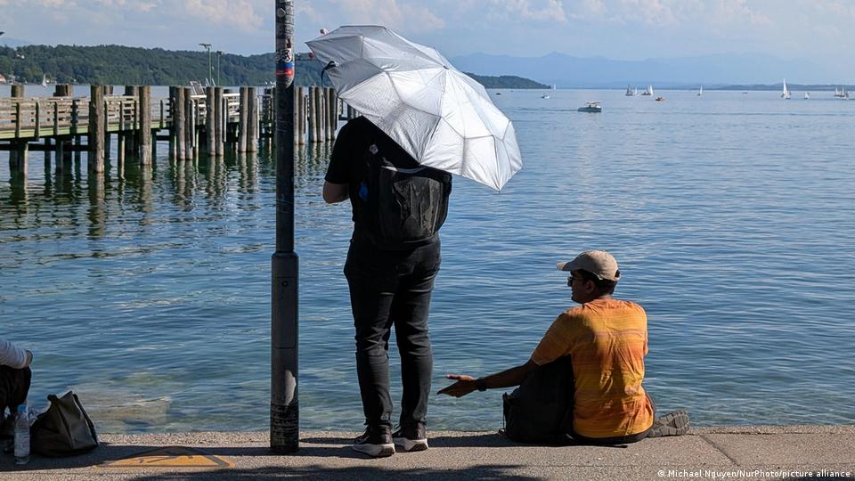 Touristen nutzen Sonnenschirme am Starnberger See in Bayern, um sich vor der Hitze zu schützen (18. Juni 2026)