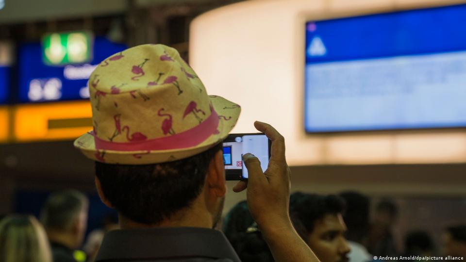 Eine Person fotografiert die Ankündigung einer Zugstörung am Frankfurter Hauptbahnhof