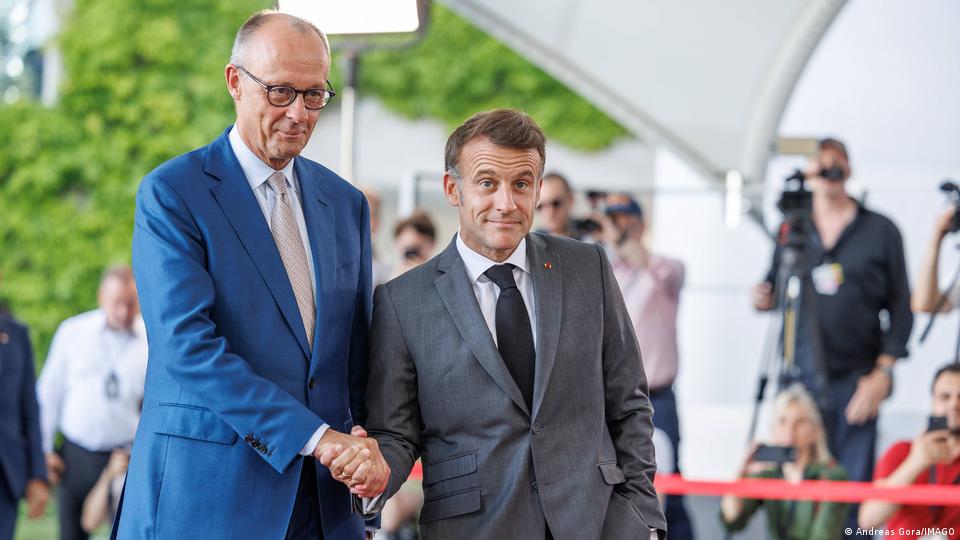Friedrich Merz und Emmanuel Macron geben sich die Hand 