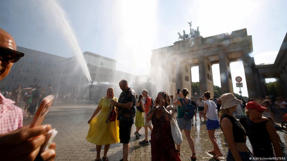 Während der anhaltenden Hitzewelle in Berlin, Deutschland, am 27. Juni 2026 genießen die Menschen das Wasser, das von einem Wasserwerfer der Polizei auf das Brandenburger Tor versprüht wird