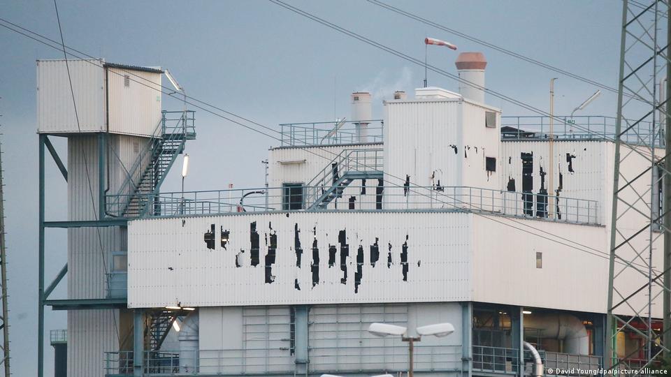 Weißes, metallverkleidetes Gebäude mit Rissen in den Wänden