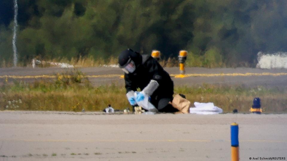 Ein Polizist in Schutzkleidung untersucht die Fundstelle einer Drohne
