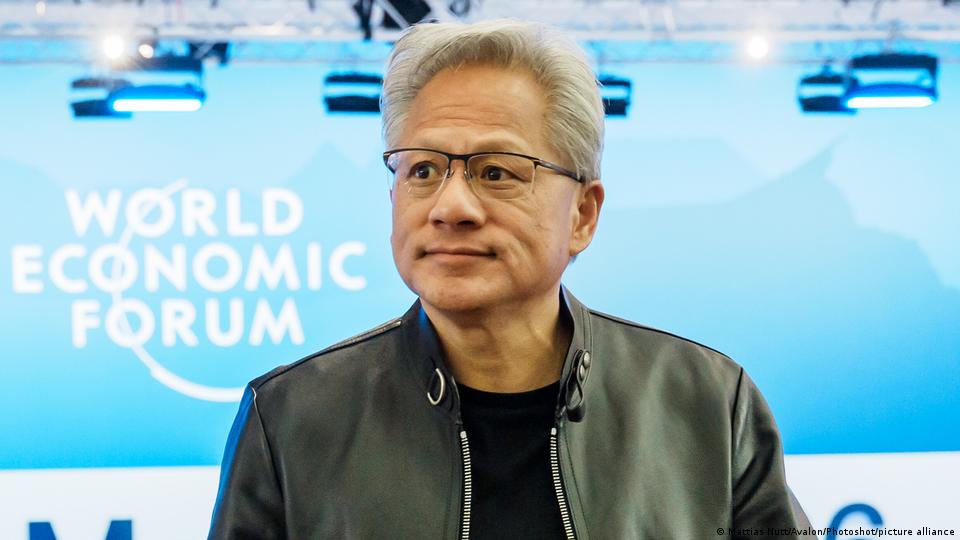 Jensen Huang, Mann mit Brille und Lederjacke, hinter ihm steht „World Economic Forum“ an der Wand