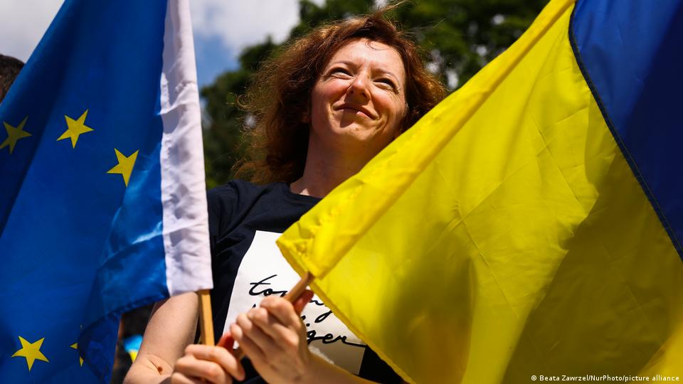 Frau hält EU- und ukrainische Flaggen