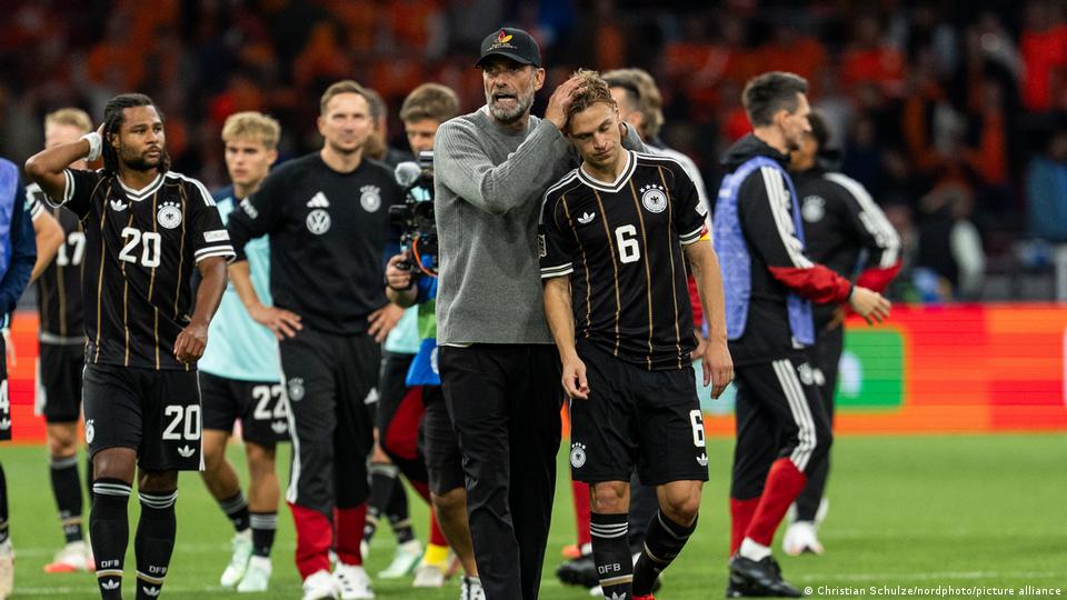 Jürgen Klopp tröstet Joshua Kimmich, indem er ihm die Haare wuschelt, während andere Germ-Spieler im Hintergrund schleifen