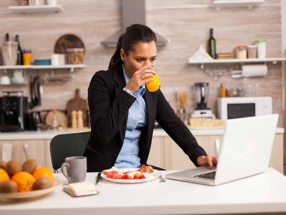 Frau in Küche am Laptop - besser ein Arbeitszimmer einrichten